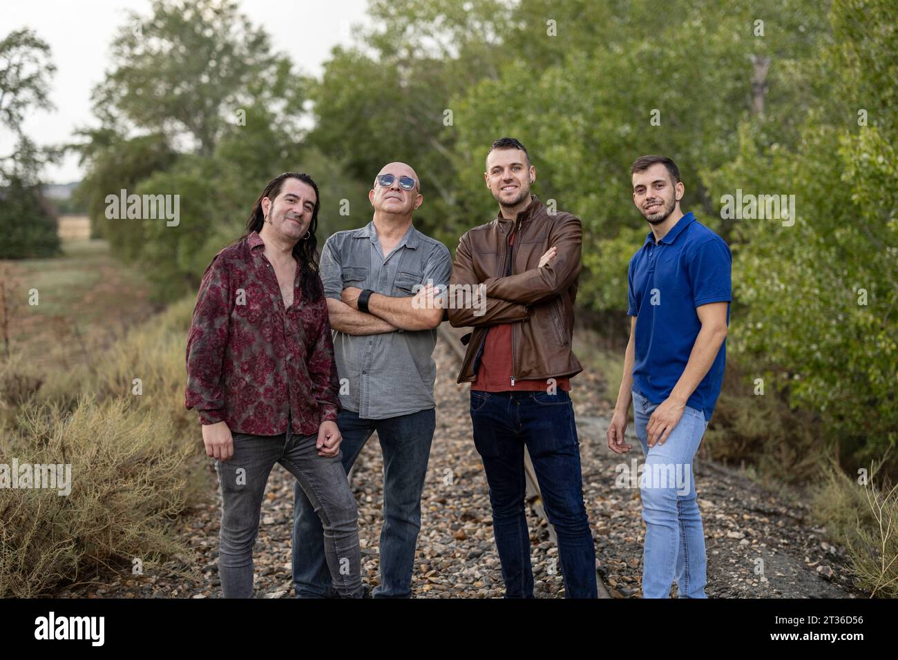 Smiling friends standing amidst plants Stock Photo