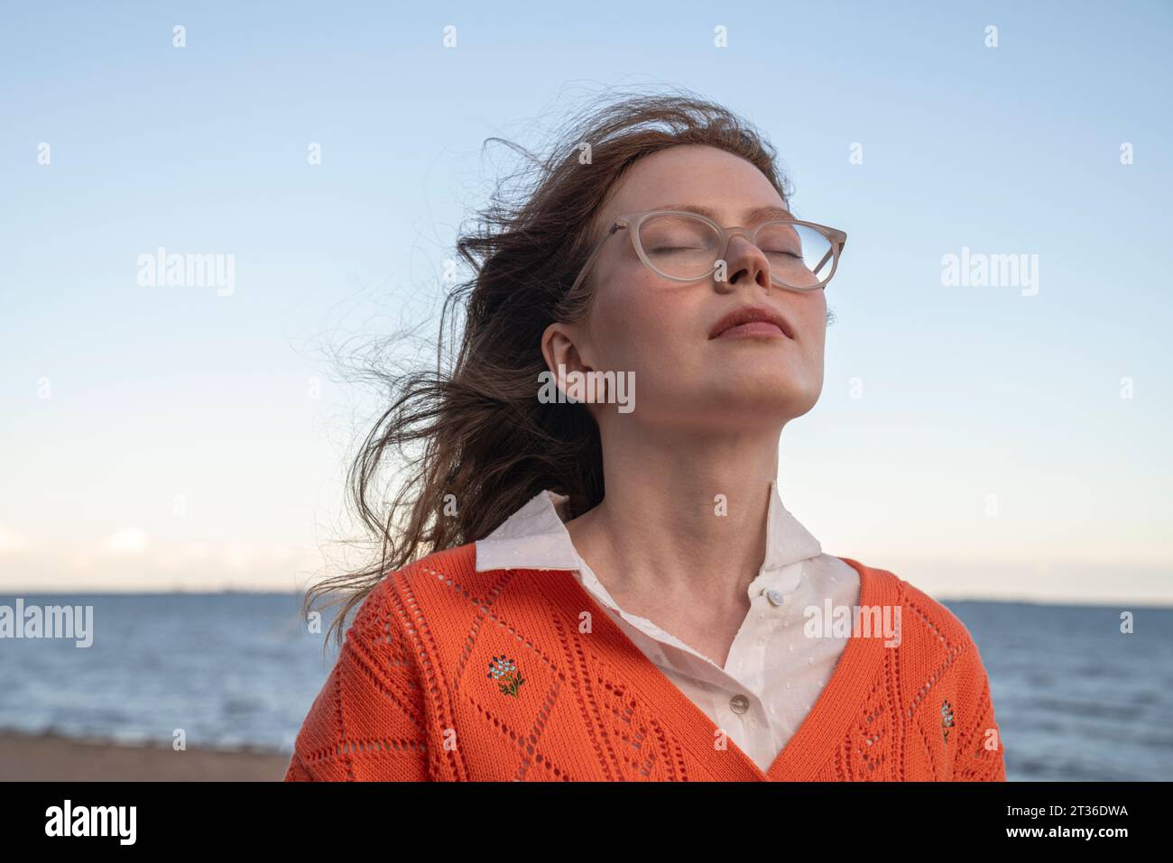 Young woman with eyes closed in front of sea Stock Photo - Alamy