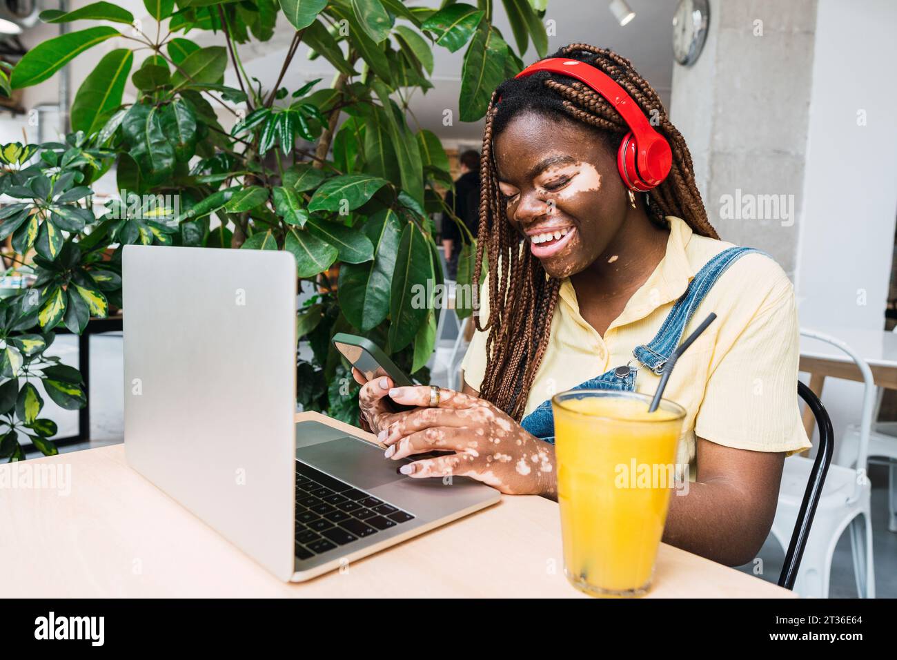 Happy freelancer wearing wireless headphones using smart phone Stock ...