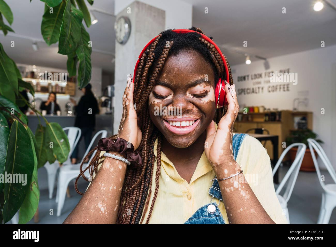 Happy young woman listening to music through wireless headphones Stock ...