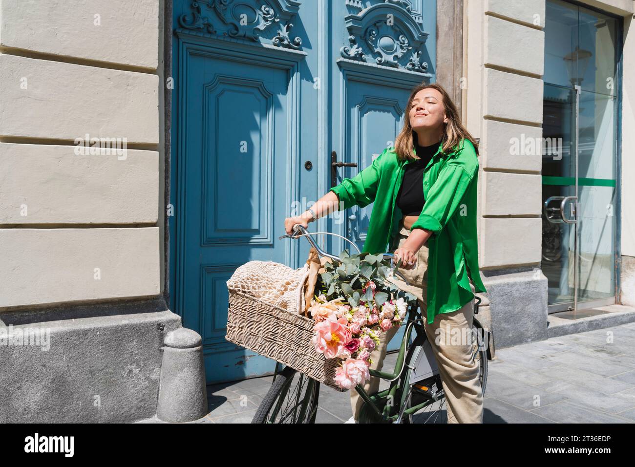 Woman riding bicycle on sunny day Stock Photo