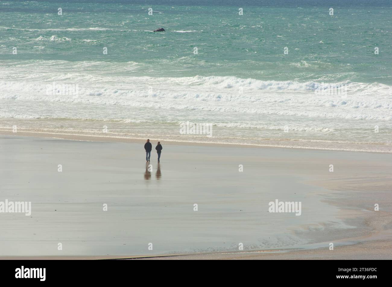 Couple enjoying a relaxing walk on the beach, Godrevy, Cornwall, UK - John Gollop Stock Photo