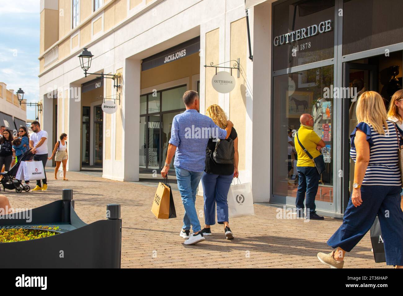 Agira, Sicily, Italy - 30 Sep 2023. Sicilia Outlet Village shopping centre is a popular visitor magnet. Passage with people where shopping at Outlet V Stock Photo