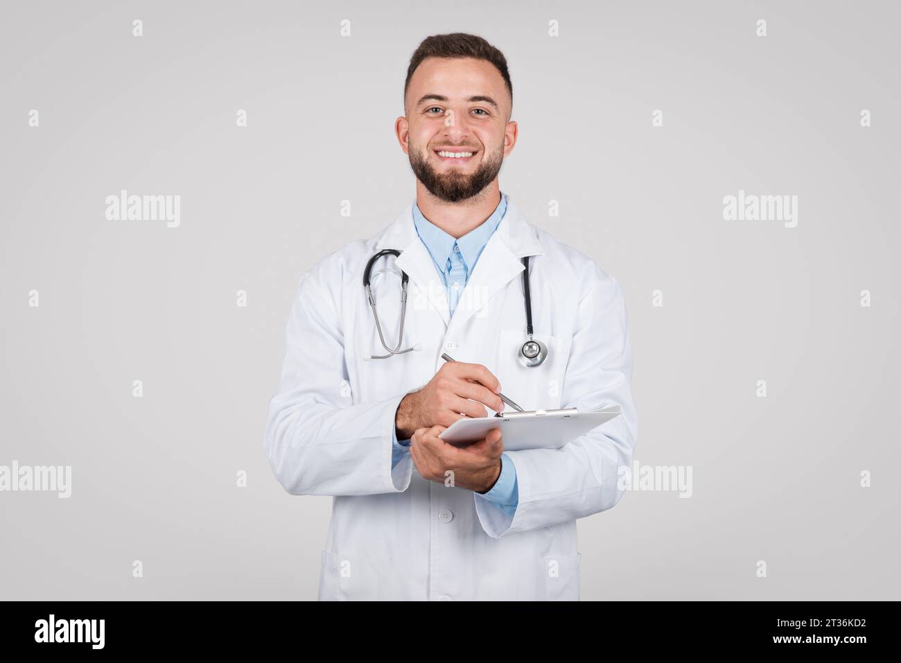 Young smiling doctor on gray hi-res stock photography and images - Alamy