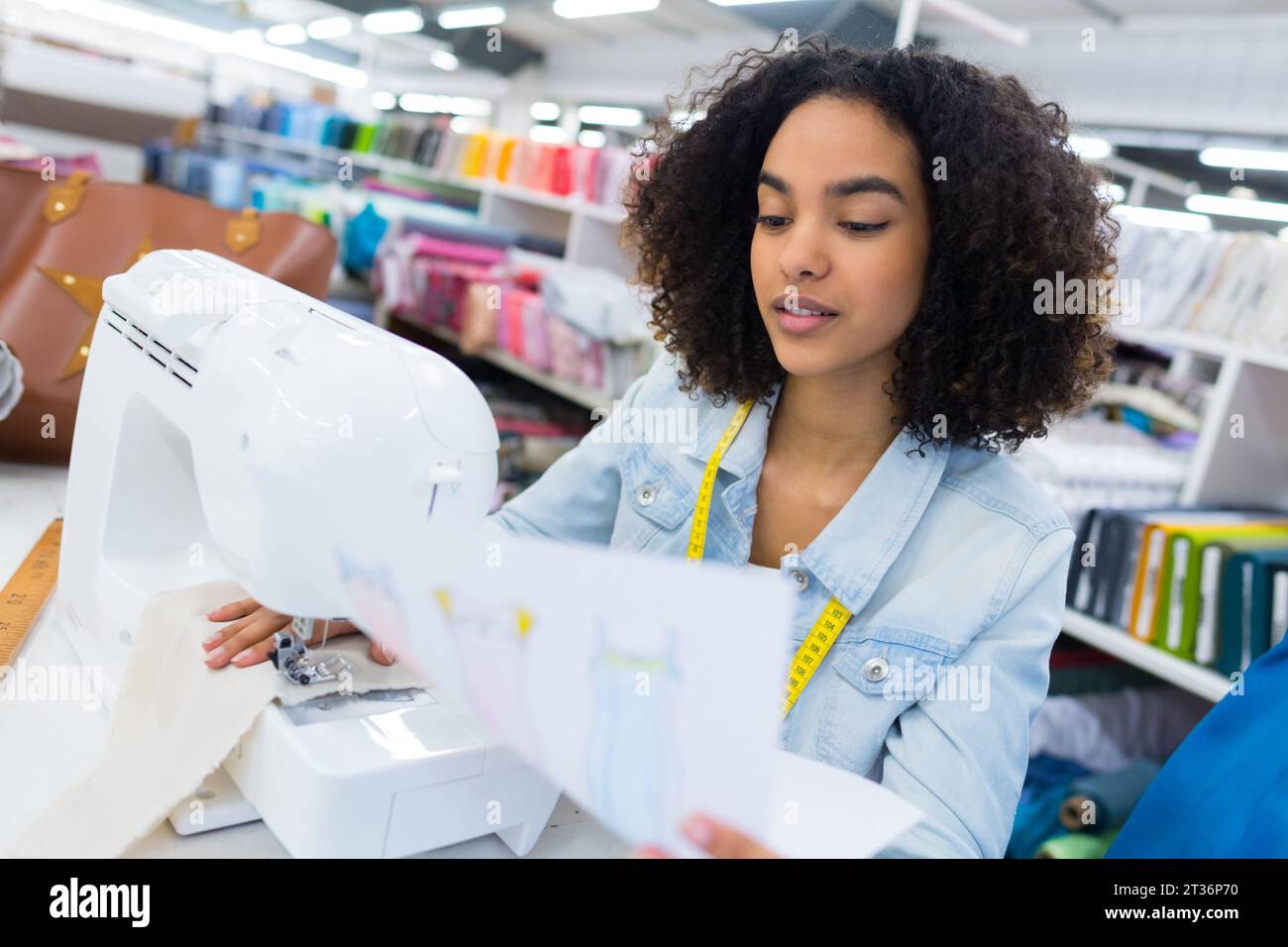 female tailor threading bobbin into sewing machine case Stock Photo Alamy