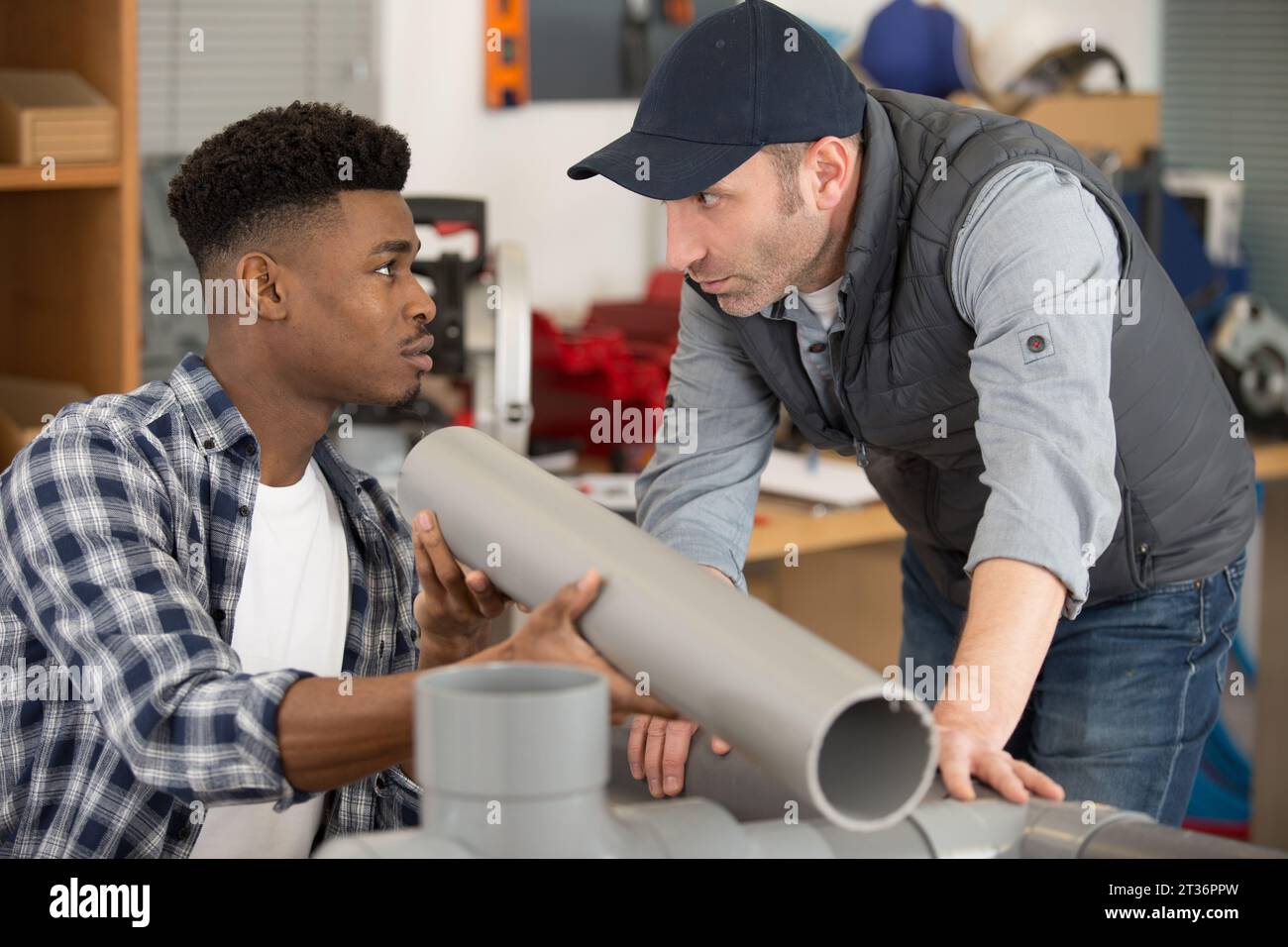 two plumbers cutting pvc pipe Stock Photo Alamy