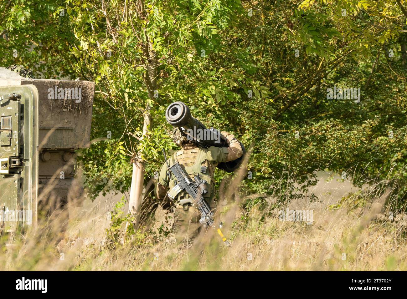 British army soldier moving in to woodland with an NLAW (MBT-LAW, RB-57) anti-tank guided missile Stock Photo