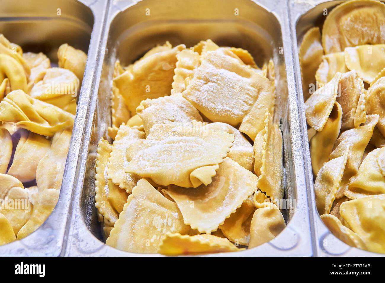 Variety of fresh stuffed pasta at market stall. Small business of