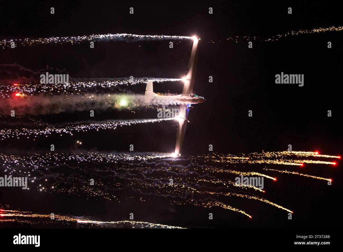 Avión lanzando fuegos artificiales por la noche Stock Photo