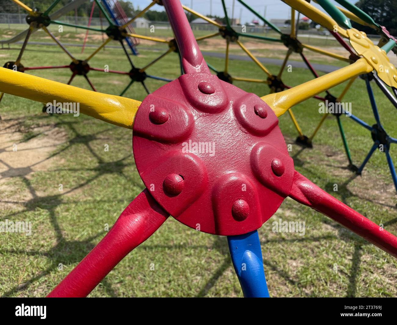 Red plate yellow and blue bars on a kiddie park monkey bars background