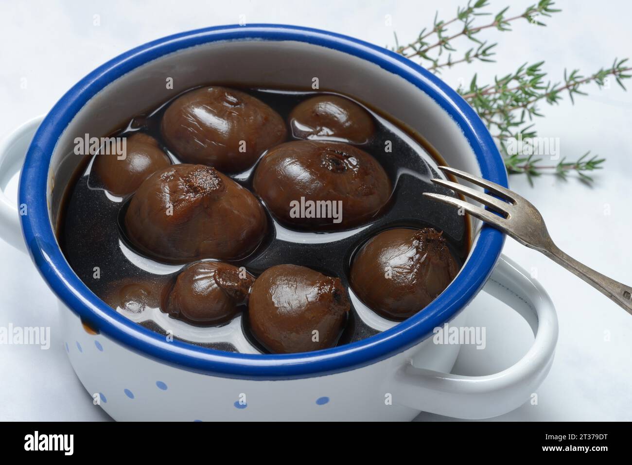 Borettane onions in pots with fork, onions in vinegar infusion of Aceto