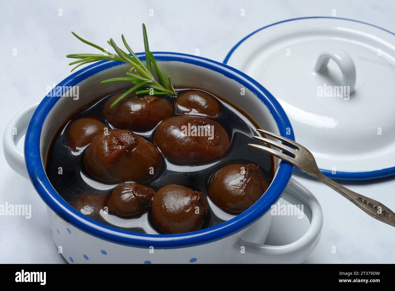 Borettane onions in pots with fork, onions in vinegar infusion of Aceto