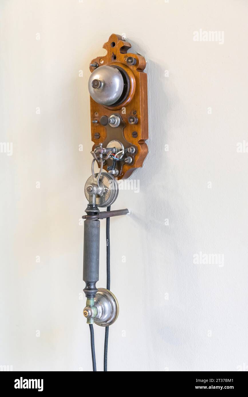 Ancient, antique telephone hanging on a room wall, historic, history, communication Stock Photo