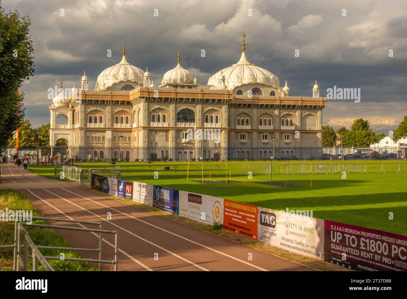 Looking at the Siri Guru Nanak Darbar Gurdwara from the adjacent sports ground with evening light Stock Photo