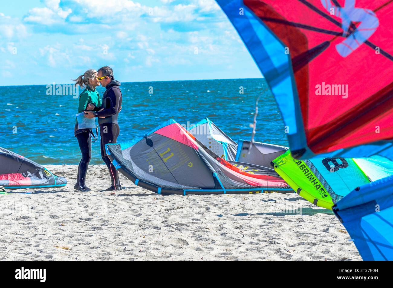 A man is told to be safe and have a great time.  As the wind catchers the kite Wind surfer go very high off the water, and at great speeds. It is fun. Stock Photo