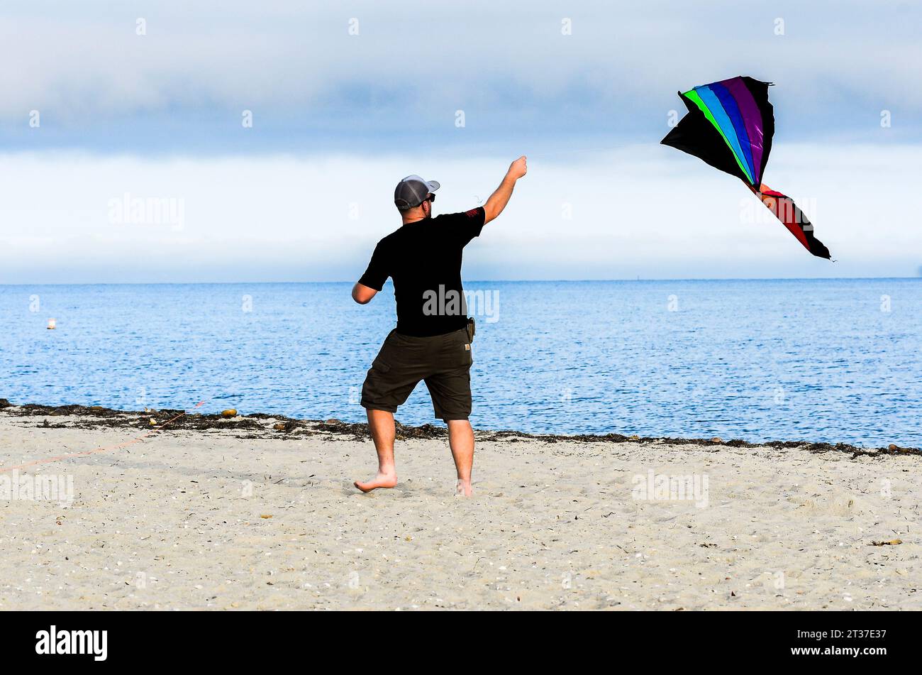 Dad go fly a kite. His children like to play in the sand more than to fly a kite.  Dad did all he could to get that kite to fly. He did get exercise. Stock Photo