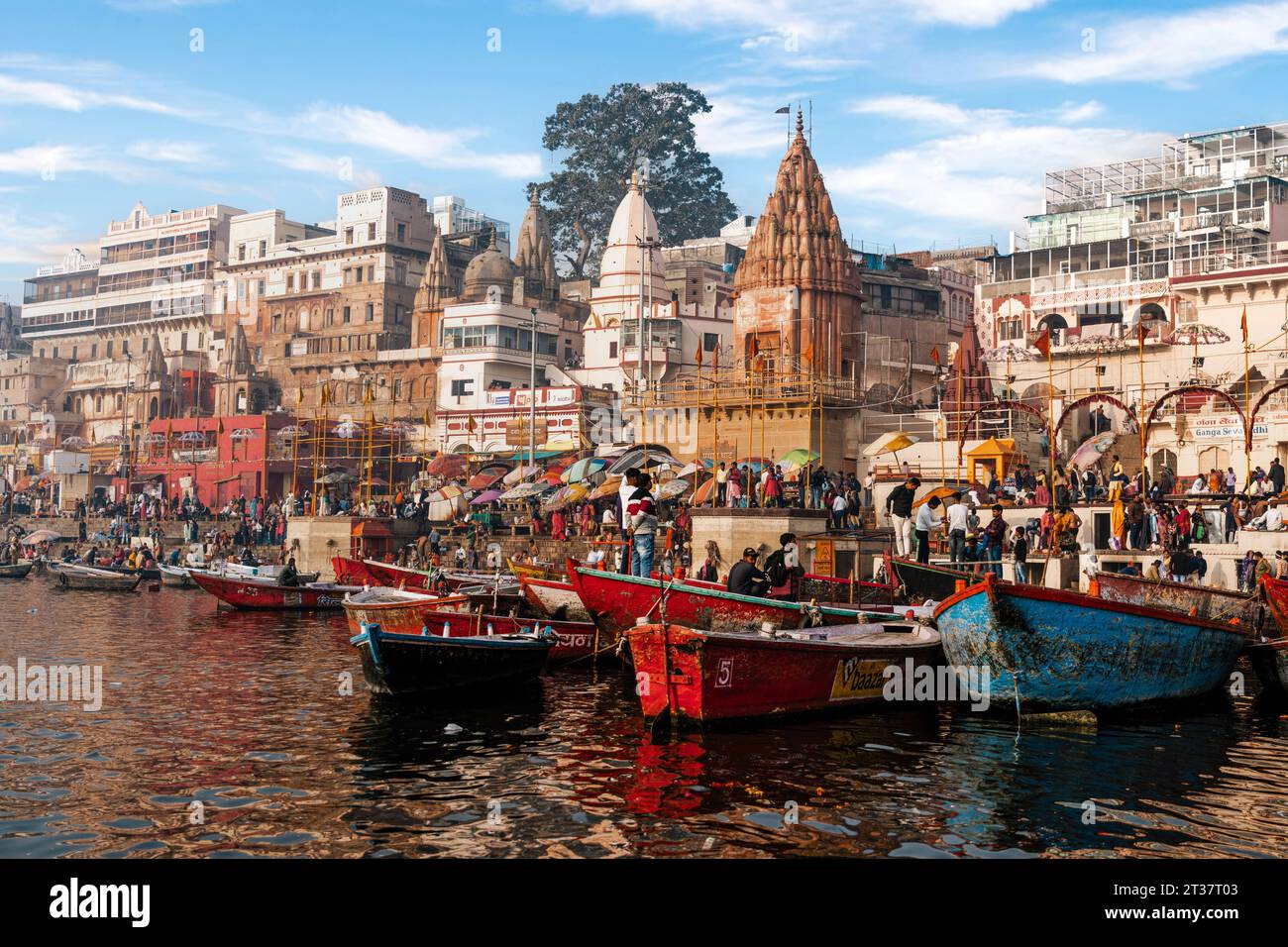 Colourful scene showing boats on the sacred Ganges River at Dashashwamedh Ghat in the holy city of Varanasi, Uttar Pradesh, India. Stock Photo