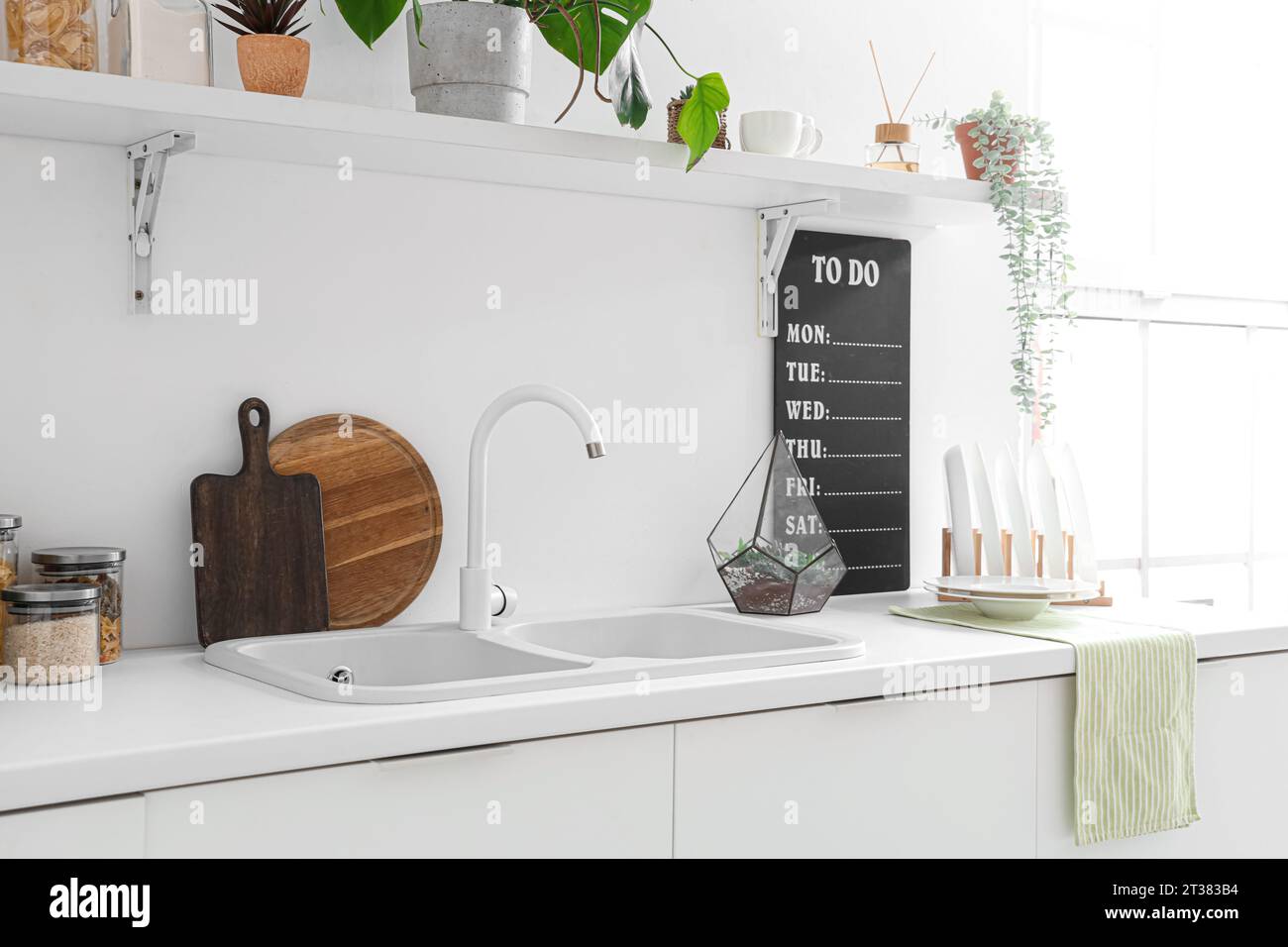 White counters with sink and utensils in interior of modern kitchen ...