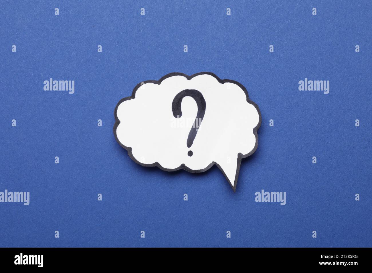 Paper speech bubble with question mark on blue background, top view Stock Photo