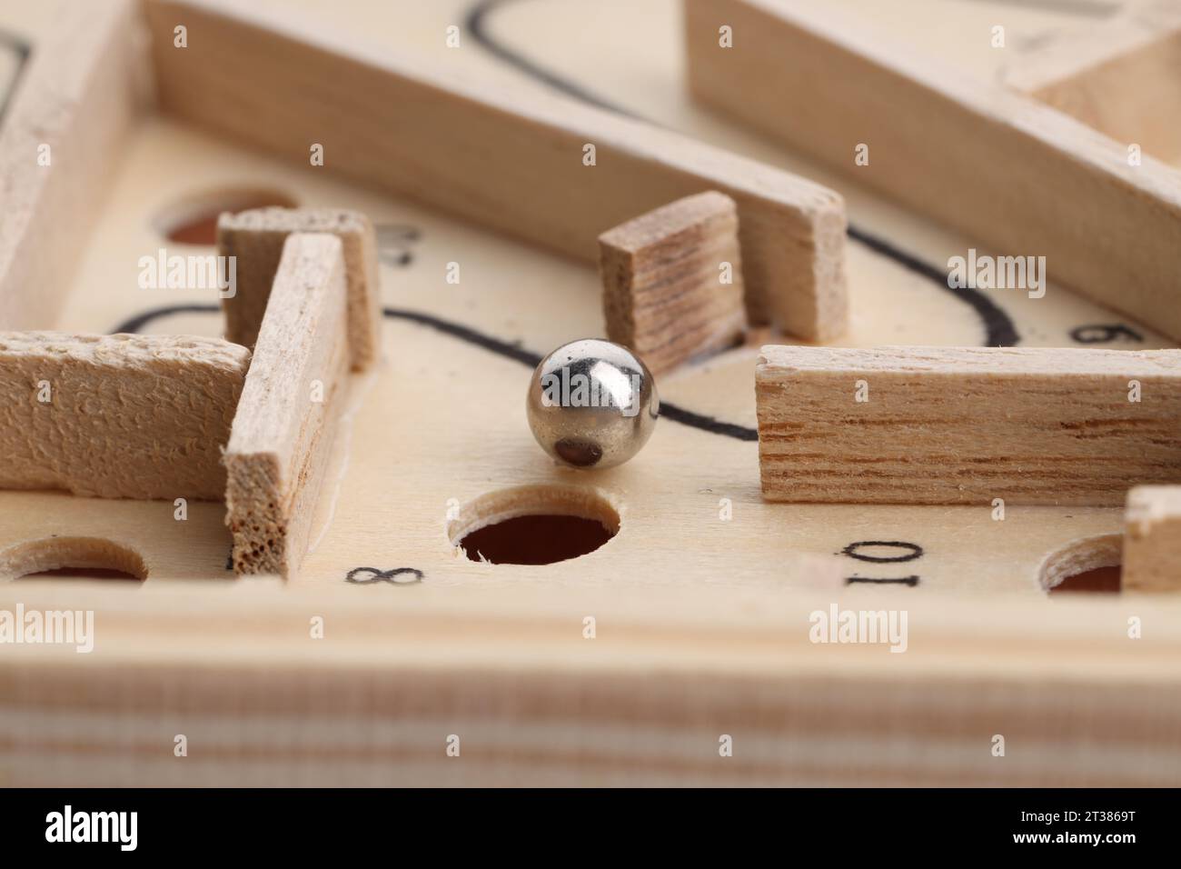 Wooden toy maze with metal ball, closeup Stock Photo
