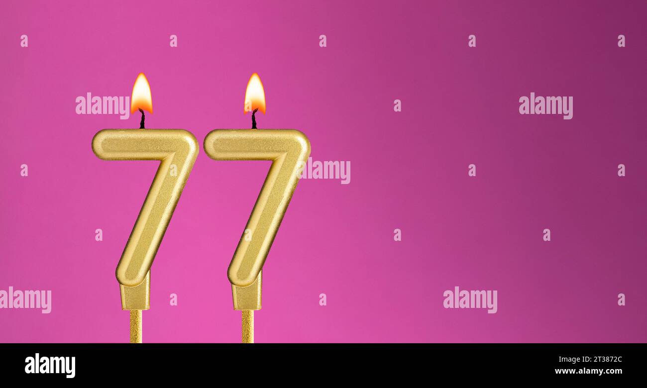 Candle number 77 in purple background - birthday card Stock Photo