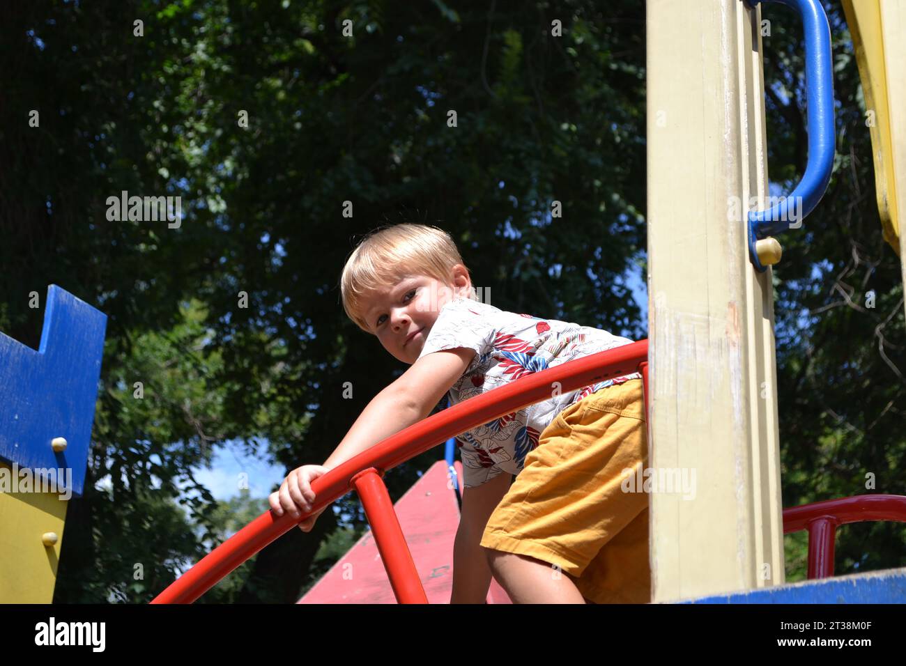 Little children run around and play in the playground. Game center for a young child. Little girl is playing outdoors. The concept of summer children' Stock Photo