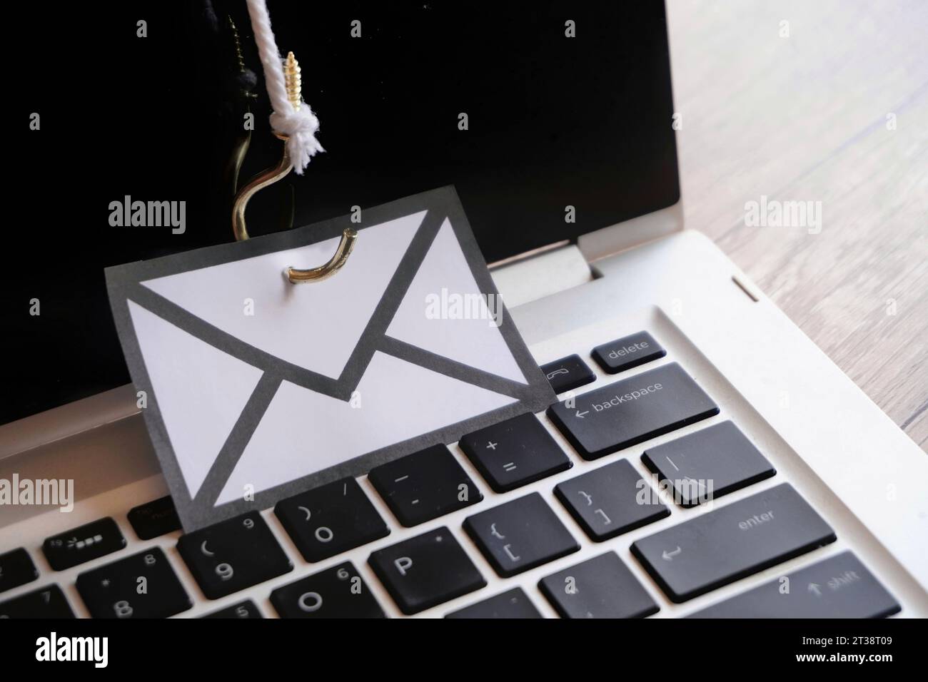 Closeup image of mail with hook on top of keyboard. Phishing email, malware and cyber security concept Stock Photo