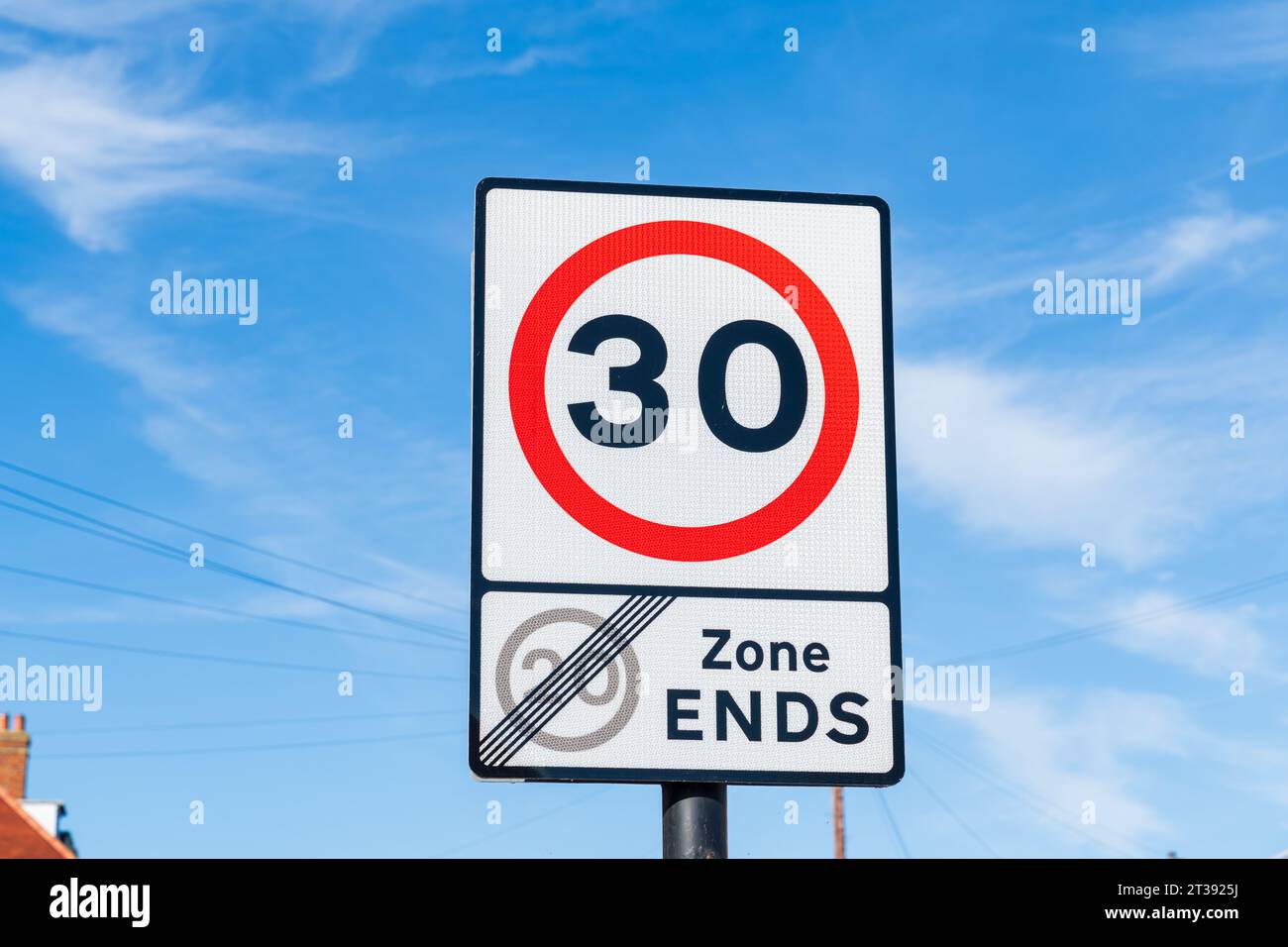 UK Traffic sign showing a 30 mph maximum speed limit after the 20 mph zone ends with a red and white warning circle Stock Photo