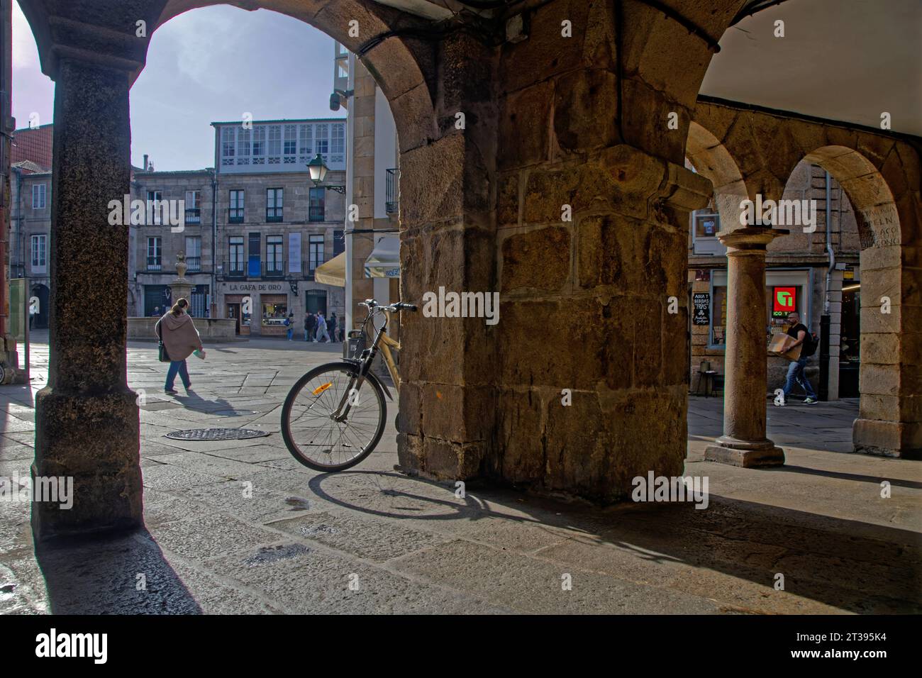 SANTIAGO DE COMPOSTELA, October 6, 2023 : Walking under the shadows and lights of the arcades of Santiago old town streets. Stock Photo