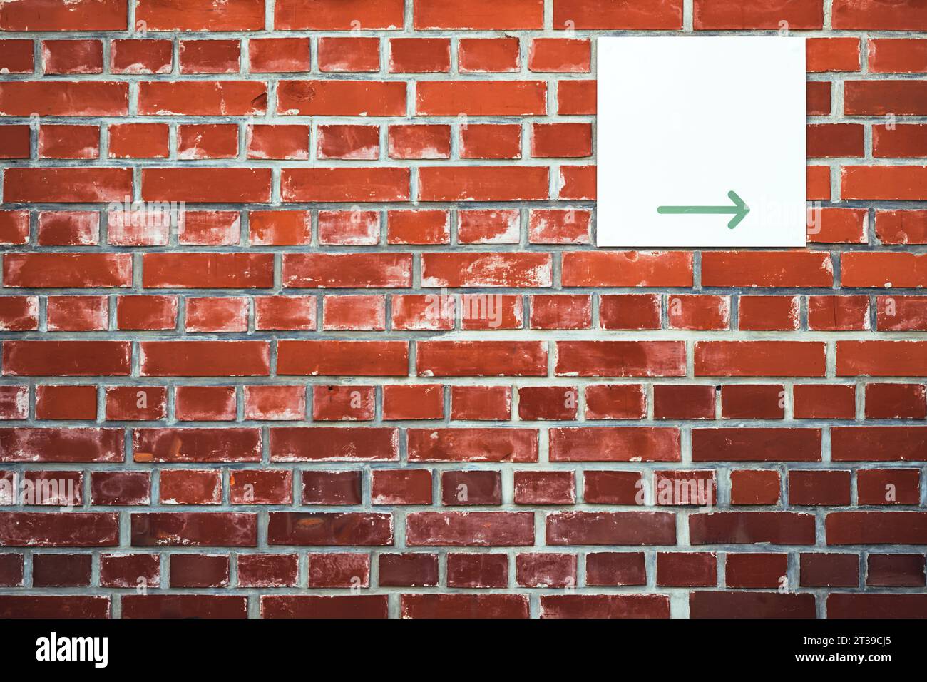 Direction arrow sign board on brick wall facade with copy space Stock Photo