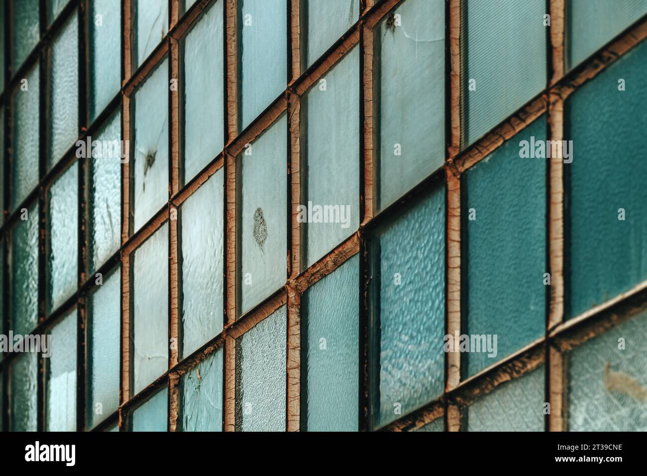 Old factory warehouse grid windows with broken glass as industrial background Stock Photo