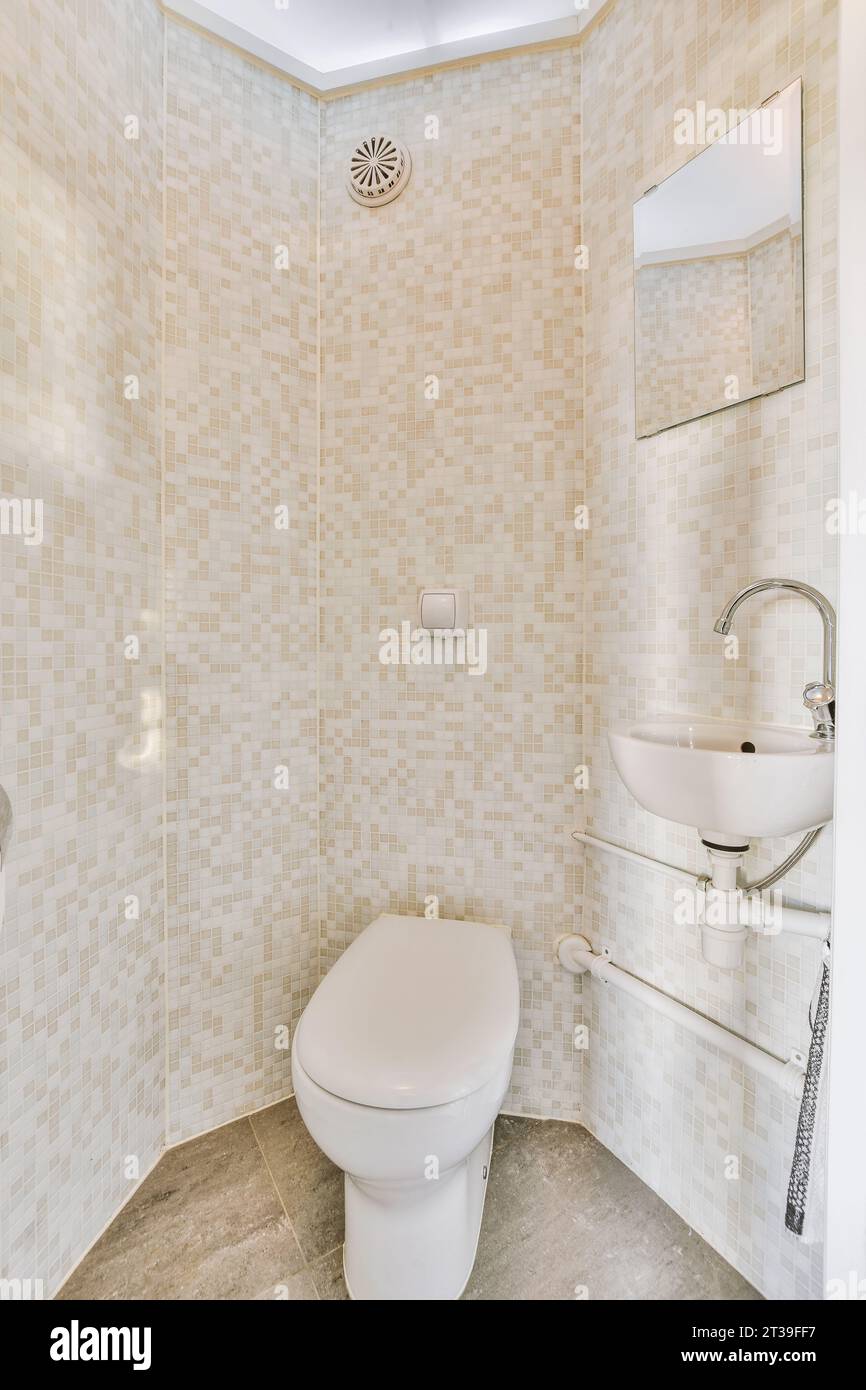 Mirror over sink and ceramic toilet bowl and seat in small bathroom