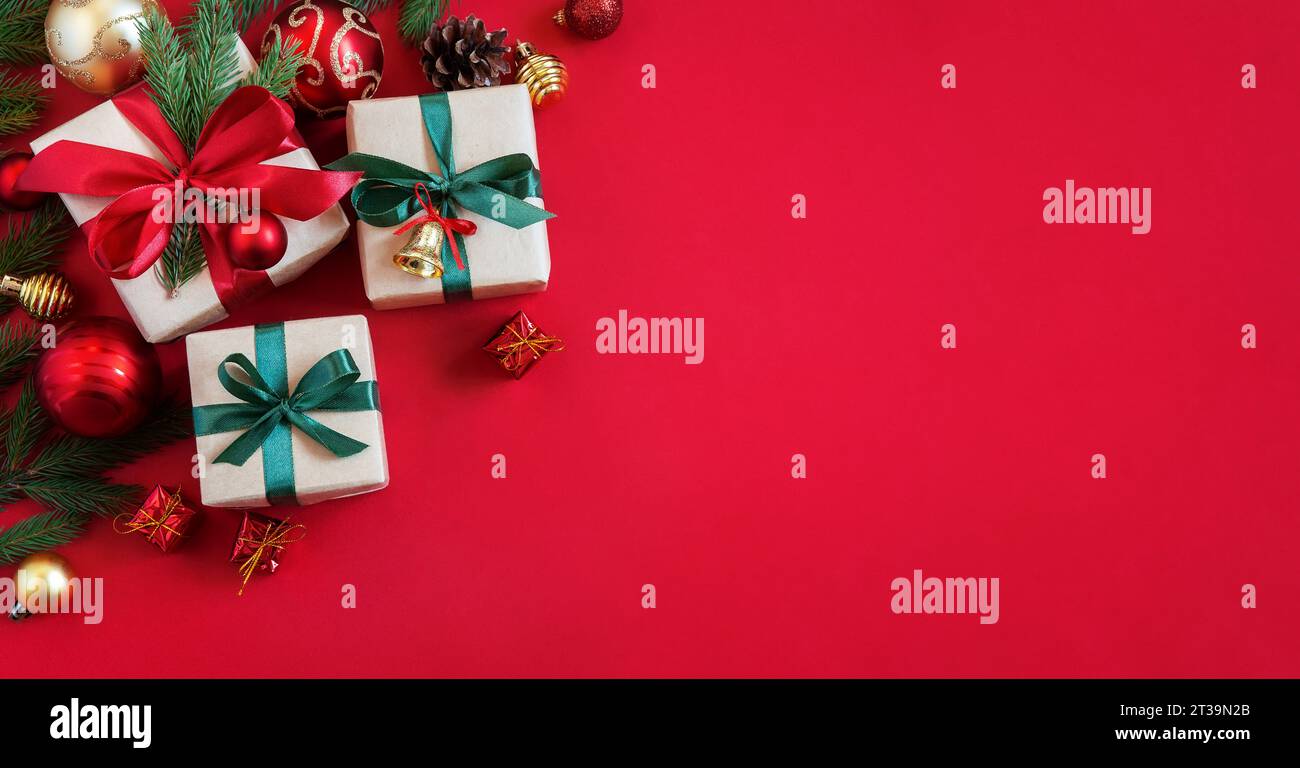 Holiday red background with gift boxes and Christmas decorations. Christmas holiday background. Top view with copy space. Stock Photo