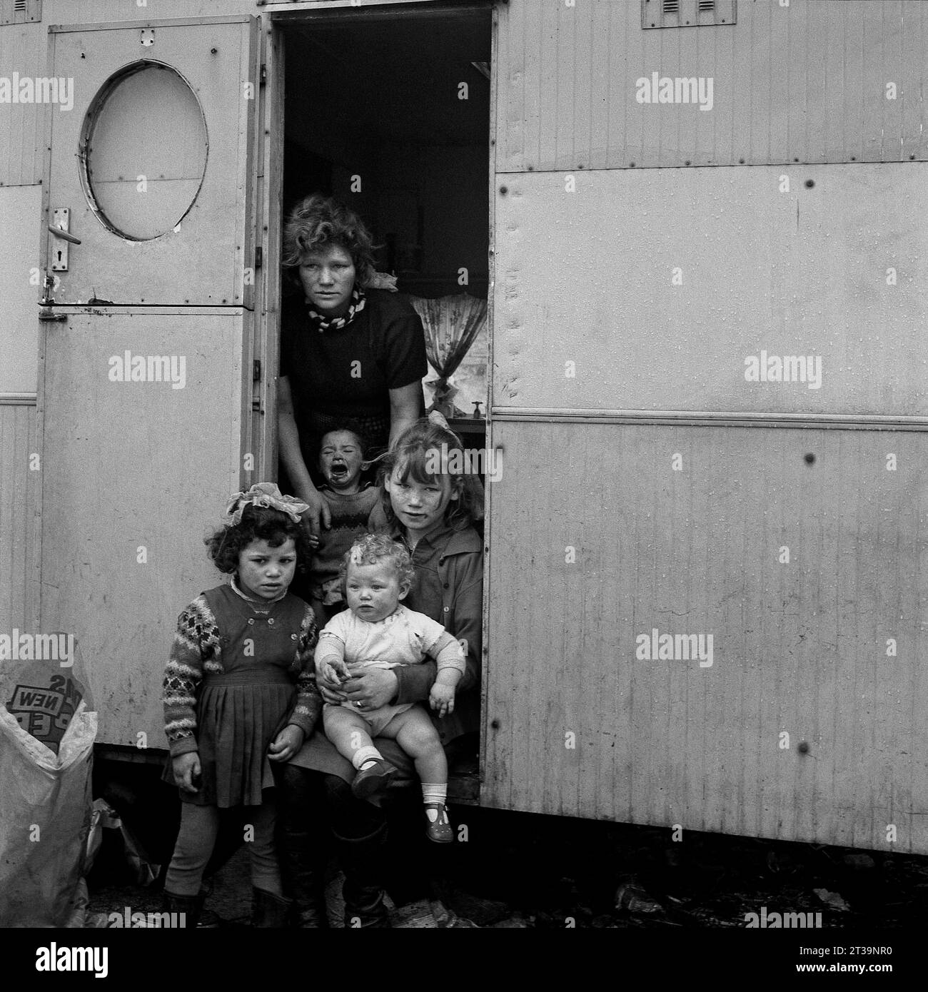 Group of young traveller children and their mother outside their caravan during the slum clearance and demolition of St Ann's, Nottingham. 1969-1972 Stock Photo