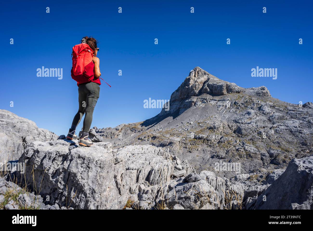 woman observing the top, Anie peak, Larra limestone plateau, Navarrese-French Pyrenees, Navarra, Spain Stock Photo