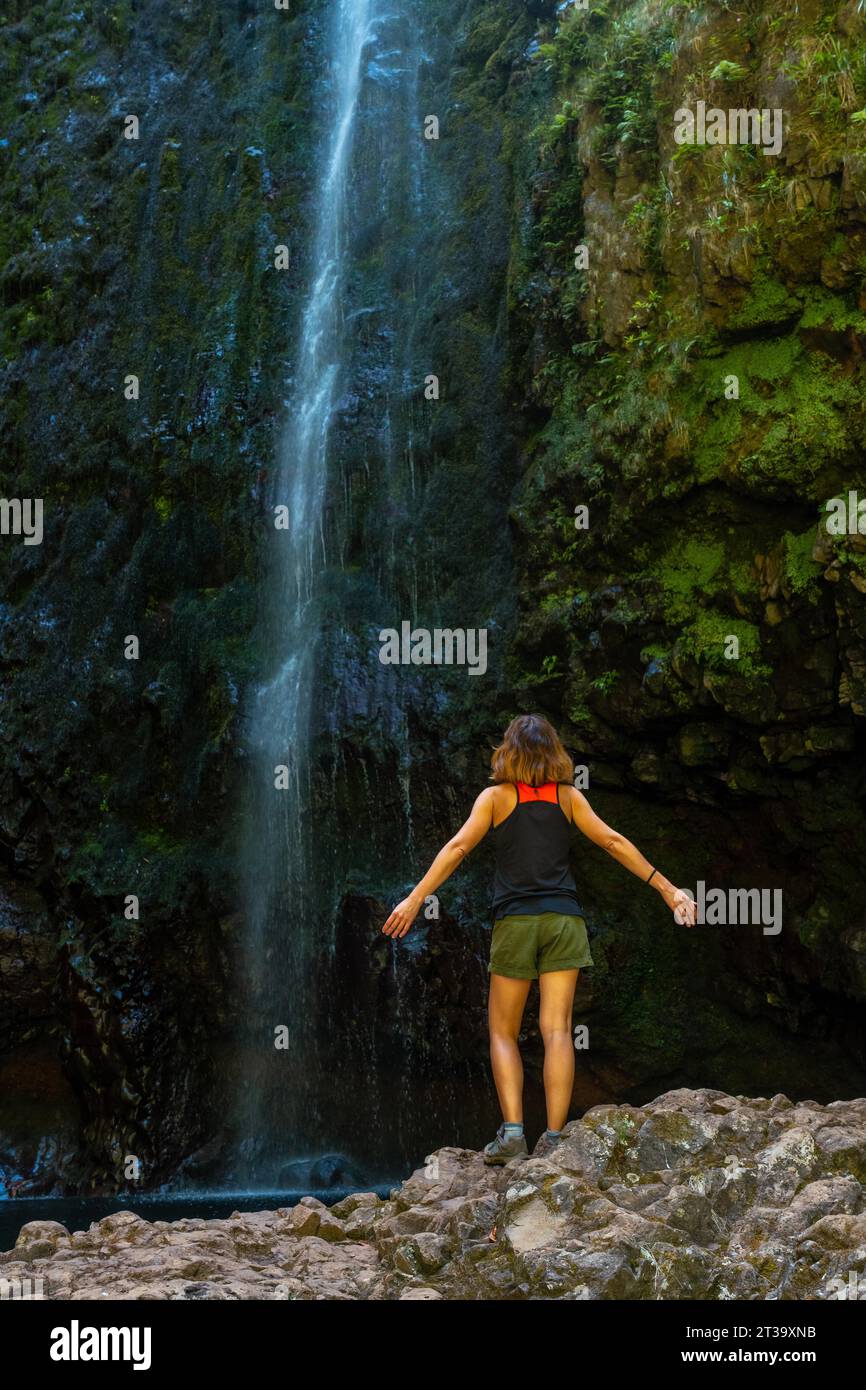 Eine junge Frau am beeindruckenden Wasserfall an der Levada do Caldeirao Verde, Queimadas, Madeira Stock Photo