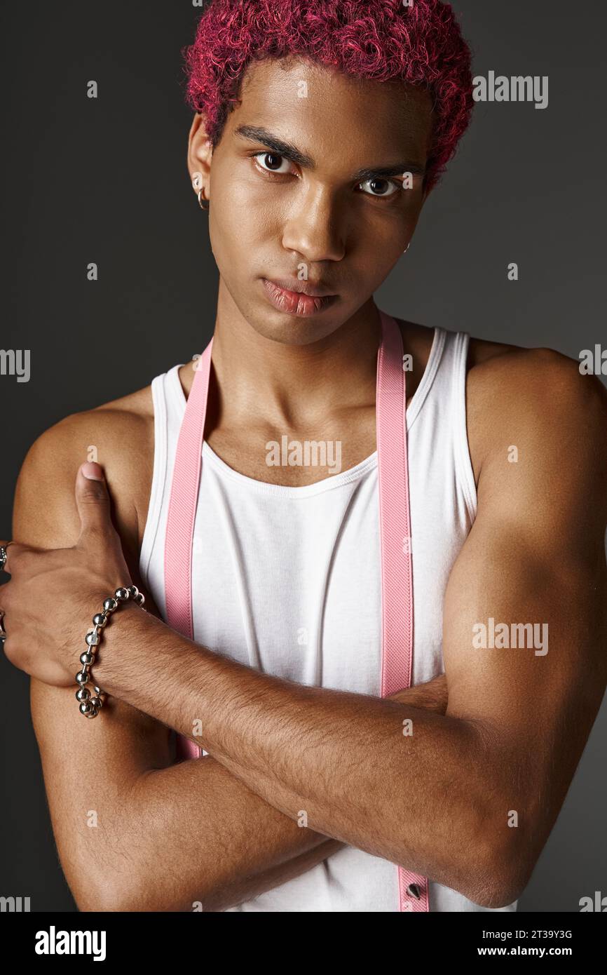portrait of young stylish man with pink hair posing with slightly ...