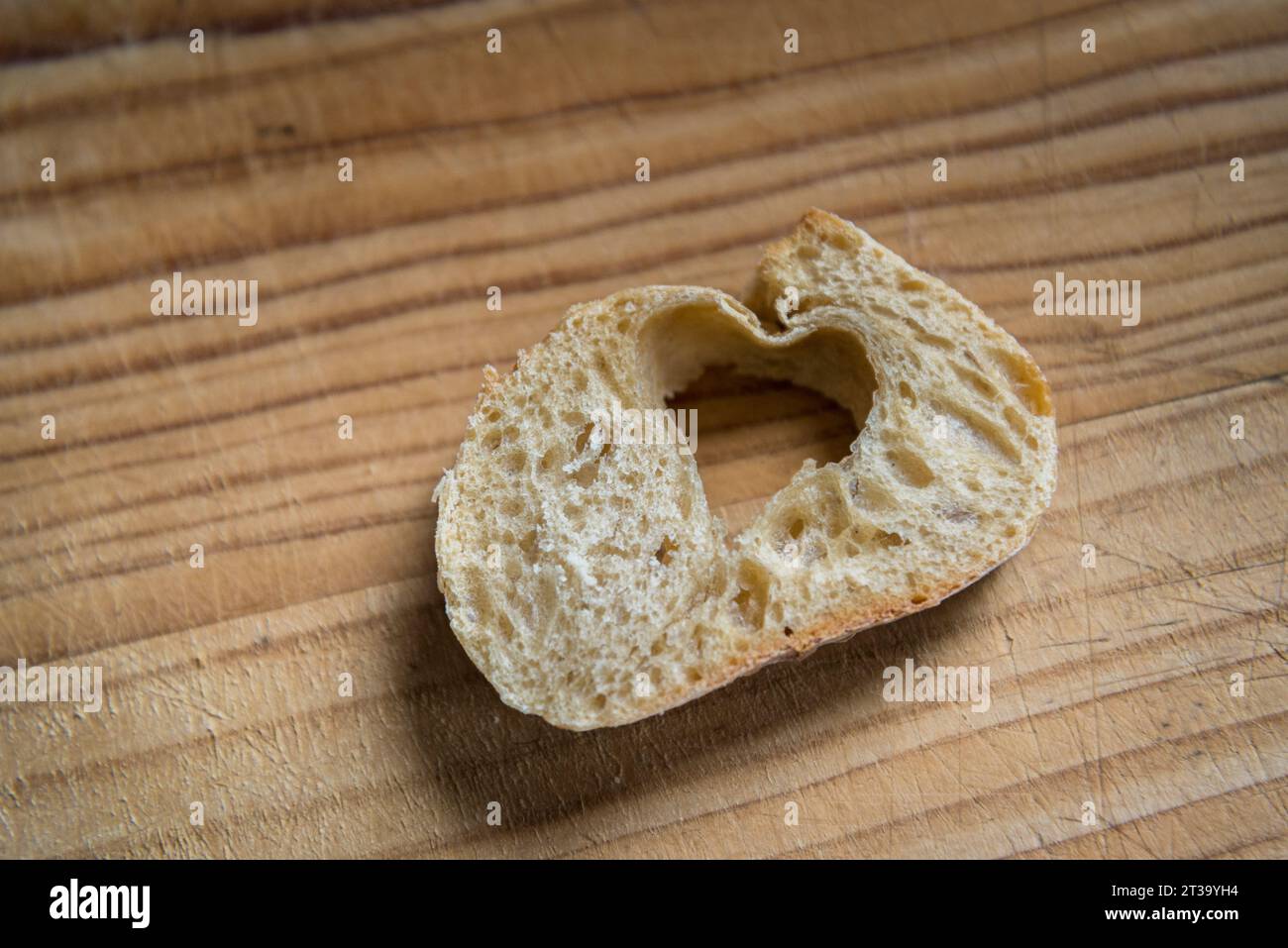 A slice of sourdough bread with a heart shape, formed by pure chance of baking Stock Photo