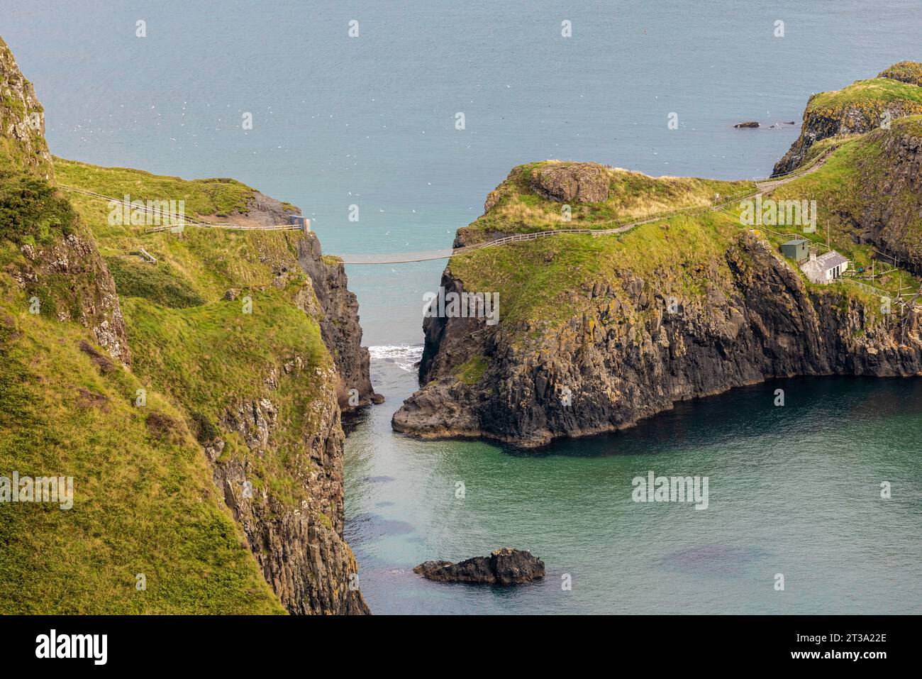 Carrick-a-Rede Rope Bridge, Northern Ireland is a 20-metre-long rope bridge spanning a 30-metre chasm, connecting the mainland to the tiny island of C Stock Photo