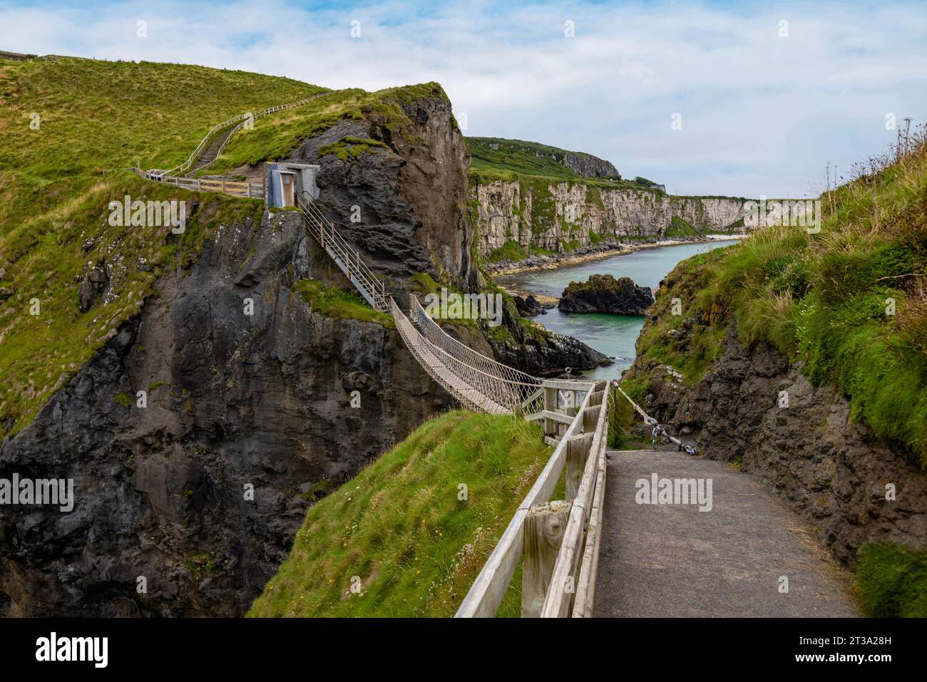 Carrick-a-Rede Rope Bridge, Northern Ireland is a 20-metre-long rope bridge spanning a 30-metre chasm, connecting the mainland to the tiny island of C Stock Photo