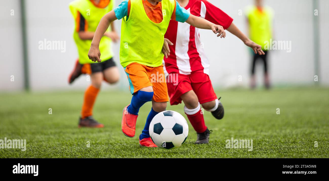 Football soccer match for children. Kids in opposite teams playing soccer games in summer tournaments. School Soccer football league Stock Photo