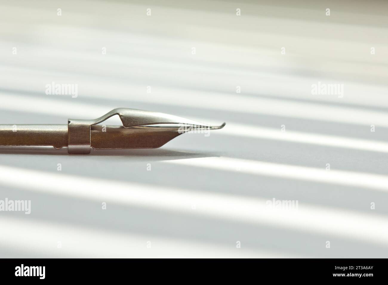 metal tip for the ink pen on a white background in solar rays ...