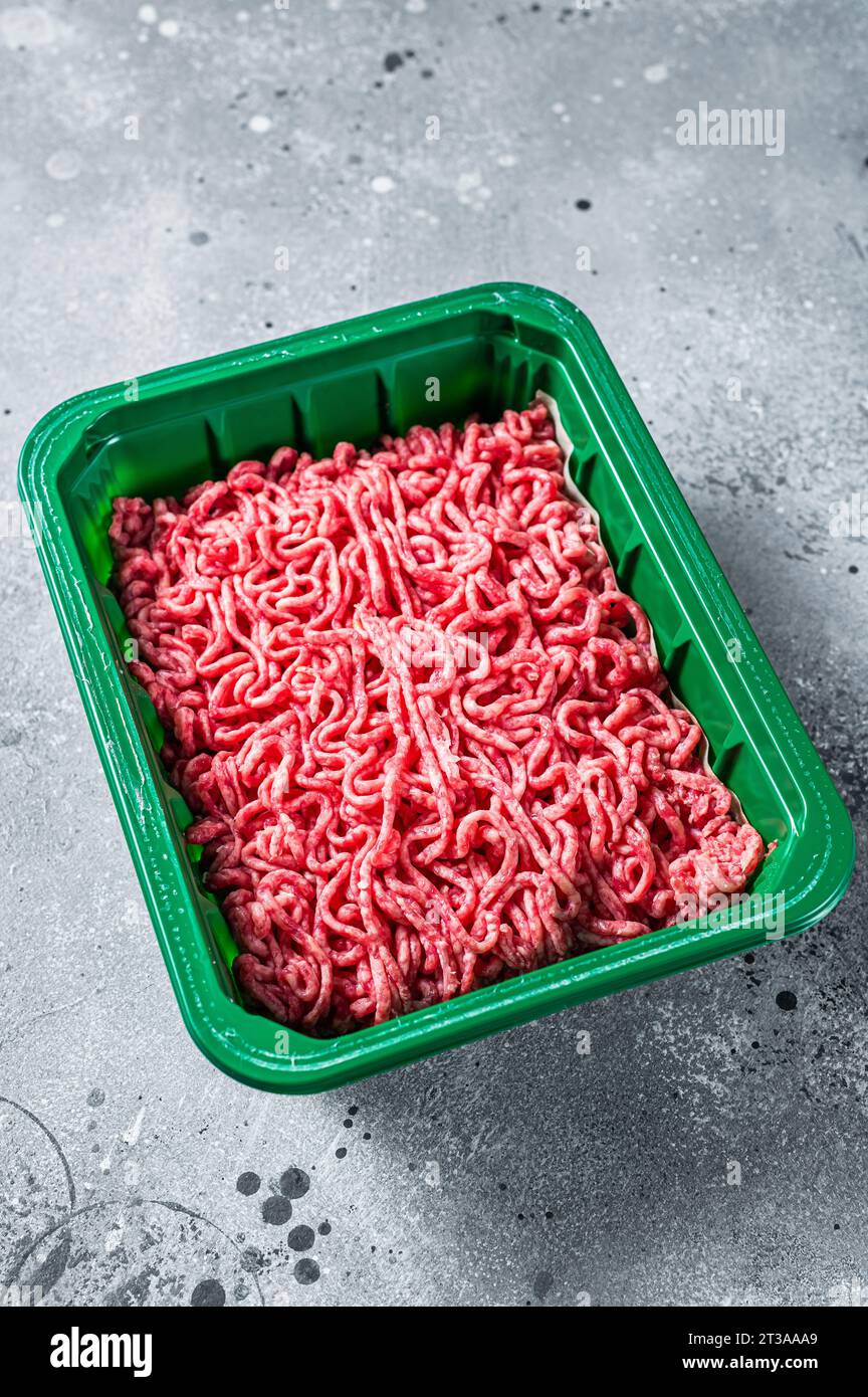 Raw Minced Meat in a Plastic Container, ground beef. Gray background