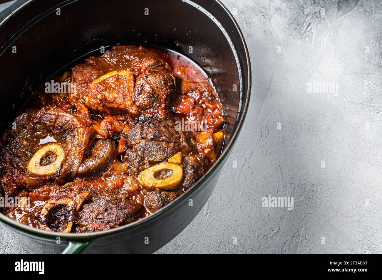 Osso buco cross cut veal shank braised with tomatoes and spices, beef meat Ossobuco. White background. Top view. Copy space. Stock Photo