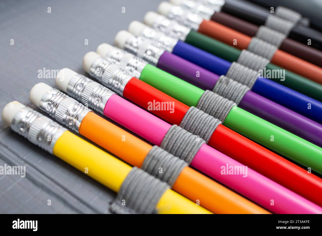 Rainbow colored pencil crayons with eraser, arranged in a pencil box, back to school abstract background Stock Photo