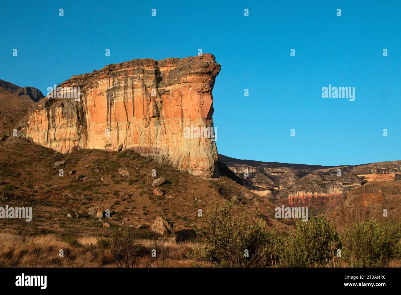 large tall cliff with sunlight; Brandwag Buttress impressive sandstone formations rock Mountain Golden Gate Highlands National Park Stock Photo