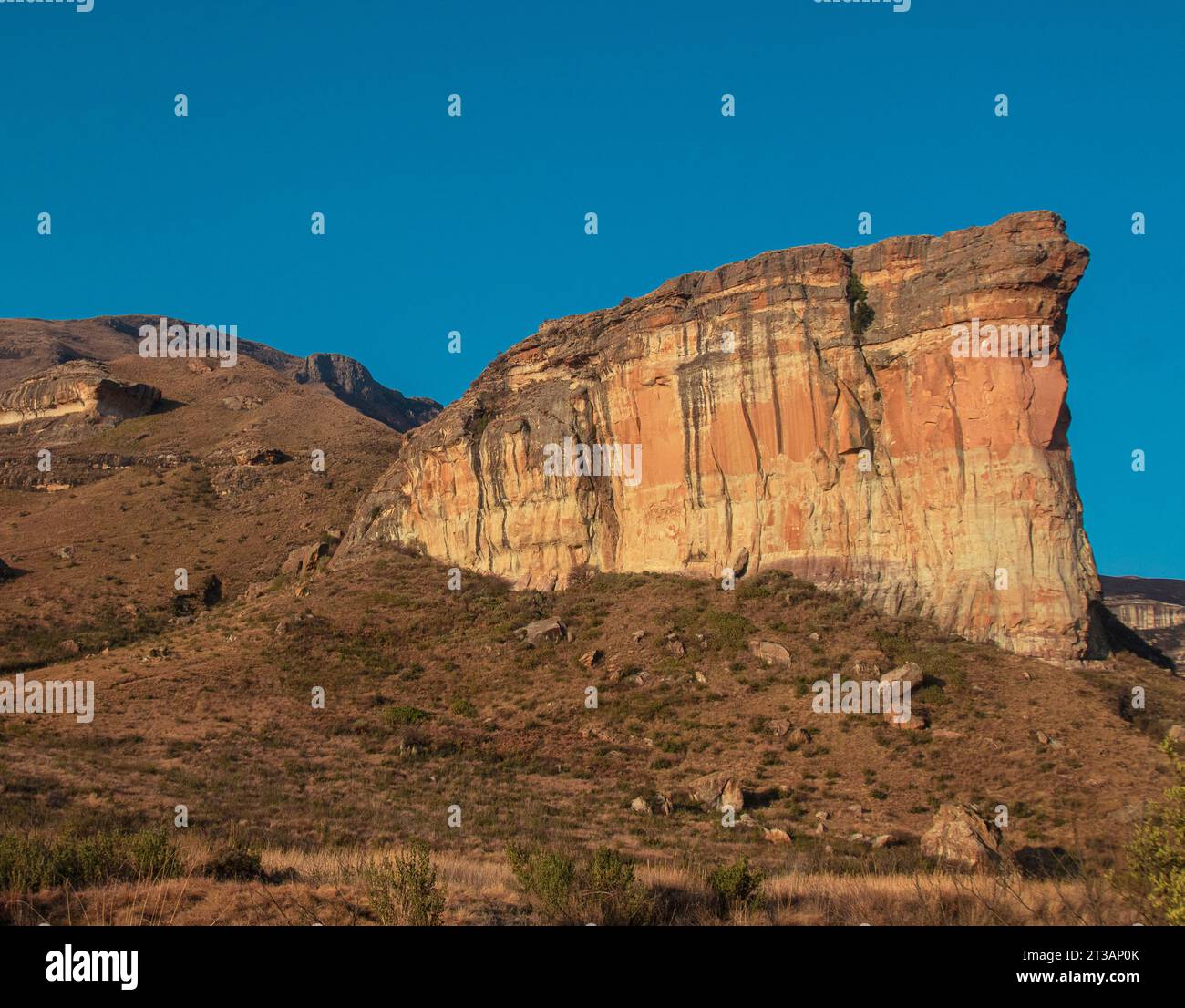 large tall cliff with sunlight; Brandwag Buttress impressive sandstone formations rock Mountain Golden Gate Highlands National Park Stock Photo