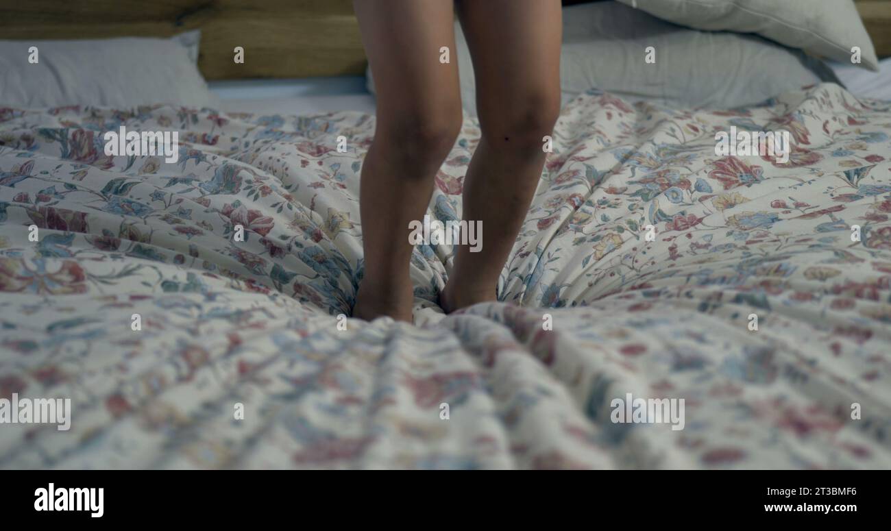 Closeup of child feeting jumping into bed in super slowmotion with