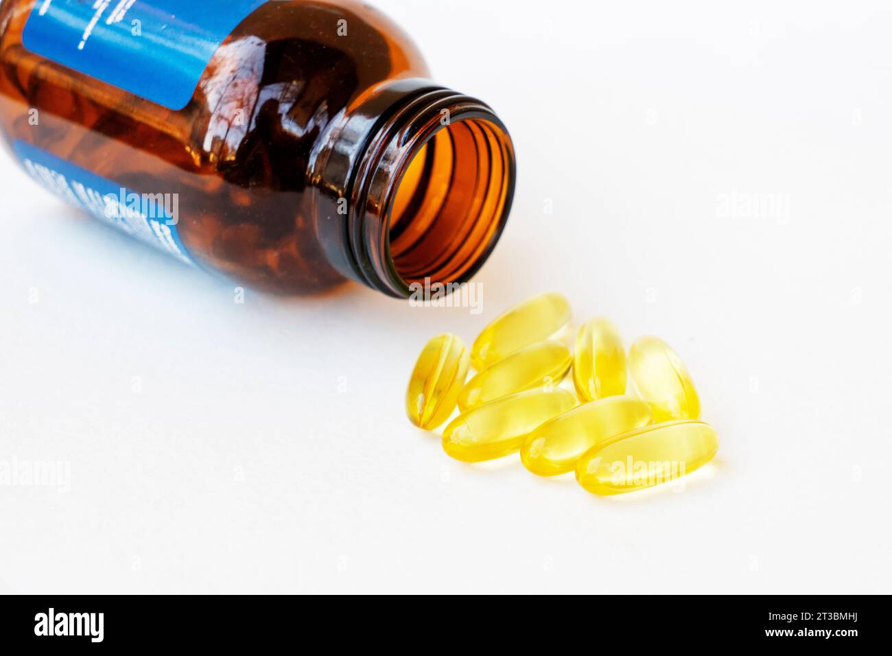 Pile of yellow fish oil capsules and pill glass bottle, fish oil
