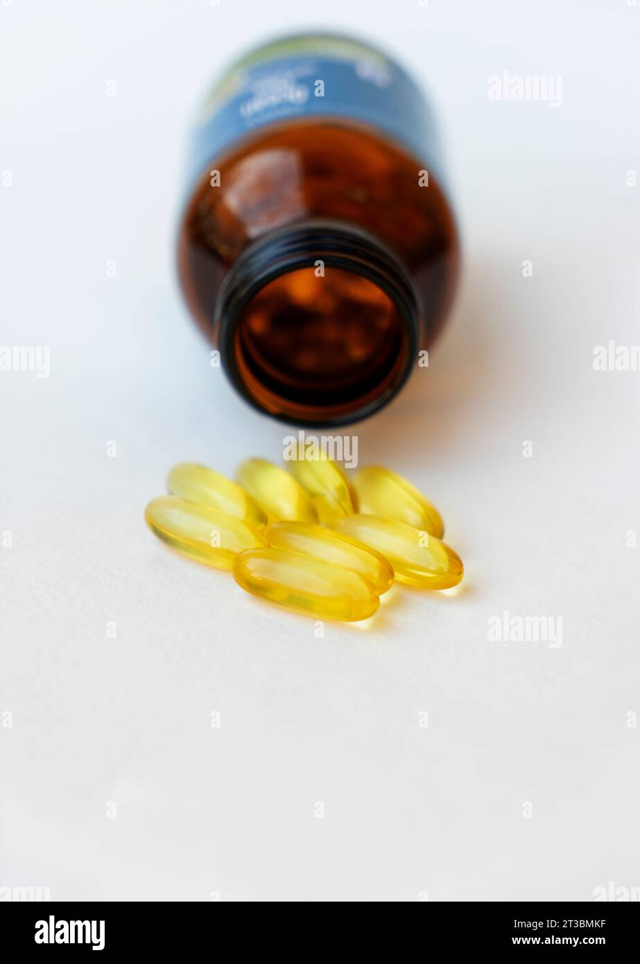 Pile of yellow fish oil capsules and pill glass bottle, fish oil